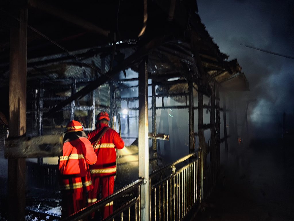 Petugas damkar memadamkan kebakaran dua rumah warga di Muara Sanga Sanga, Kutai Kartanegara.