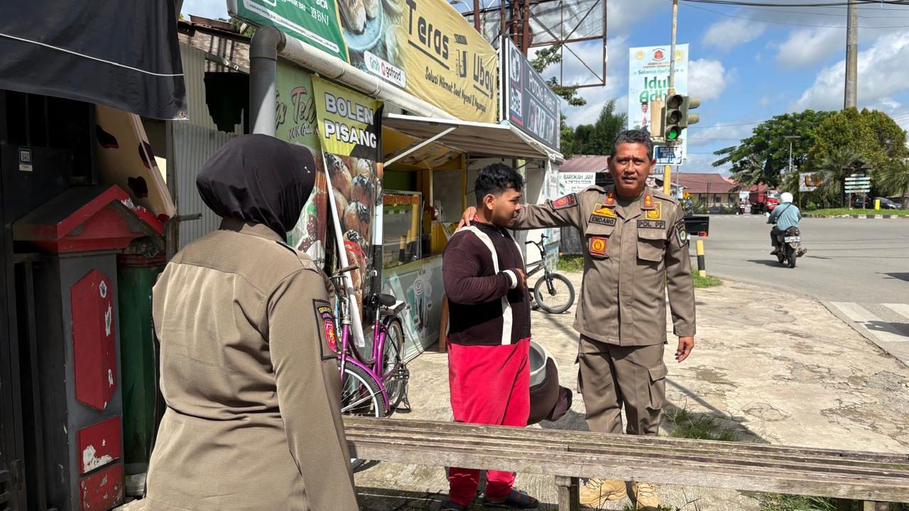 Petugas Satpol PP Kukar menertibkan seorang badut yang beraktivitas di kawasan lampu merah Simpang Unikarta, Tenggarong, Senin (22/6/2026).